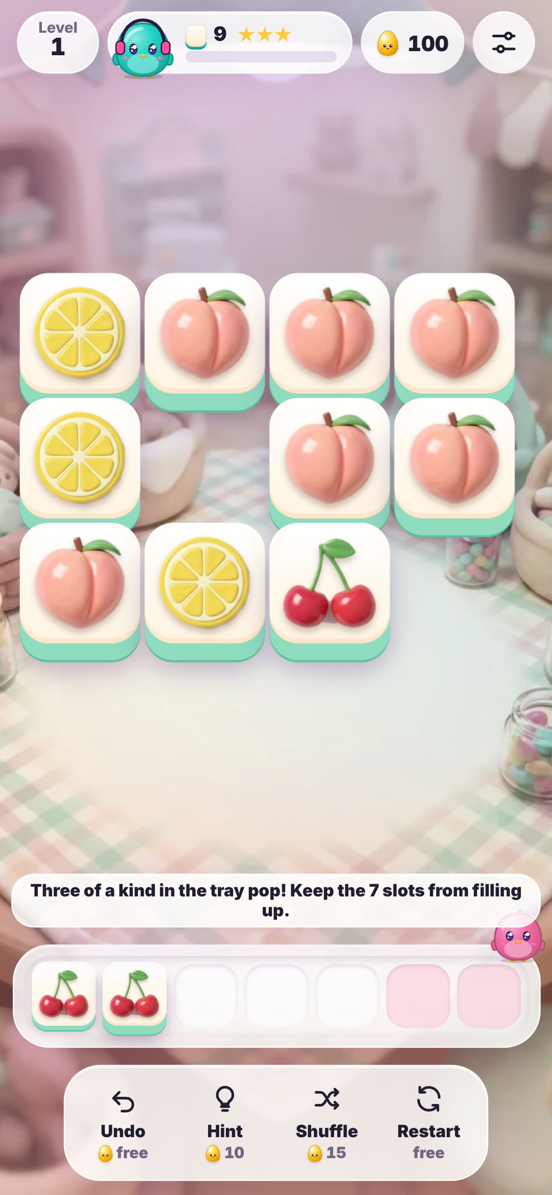 Tile Trio level 1 on a phone with fruit tiles, two cherries in the tray and the tip explaining that three of a kind pop